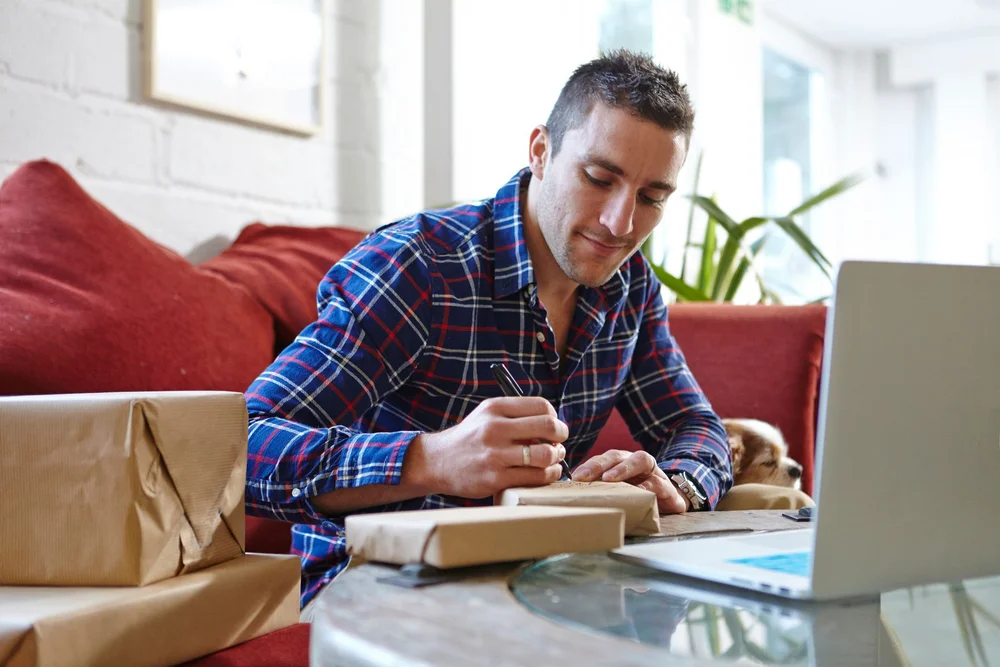 mężczyzna przygotowujący zamówienia do wysyłki